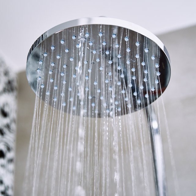 Modern rainfall showerhead with water running, custom shower installation in Kitchener.